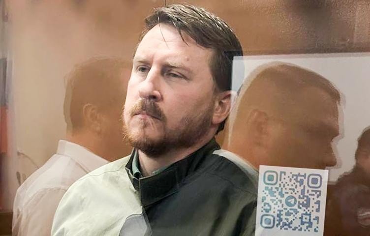 мужчина сидит за стеклом