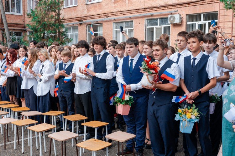 Школьники аплодируют в школьном дворе