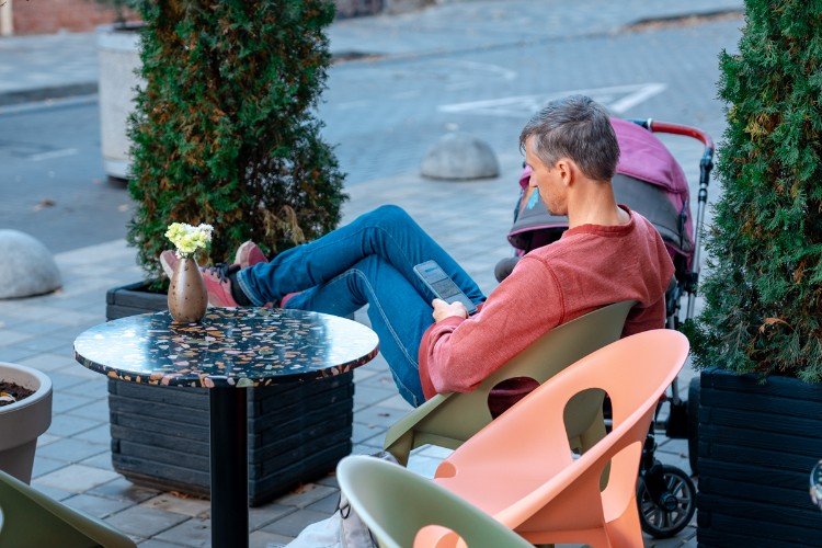 мужчина сидит на стуле и смотрит в телефон