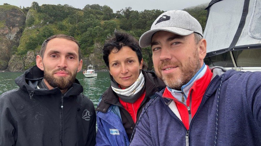 три человека стоят на фоне гор