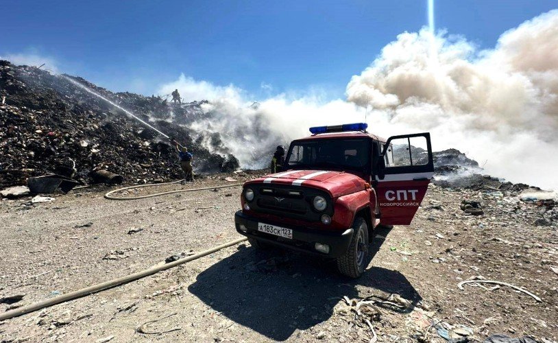 машина стоит около горящей свалки