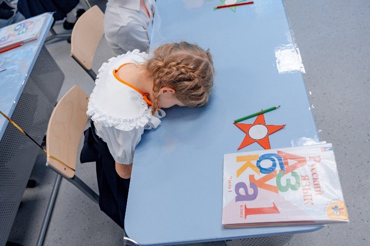 девочка легла на парту