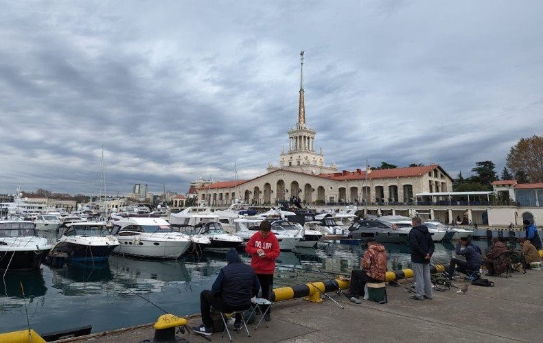 рыбаки сидят у морвокзала в Сочи