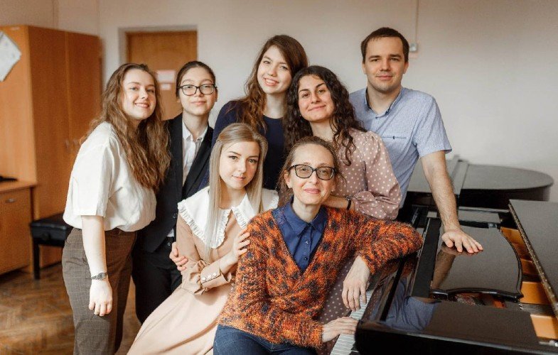 люди сидят около пианино