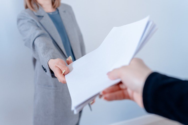 девушка передает пачку бумаги