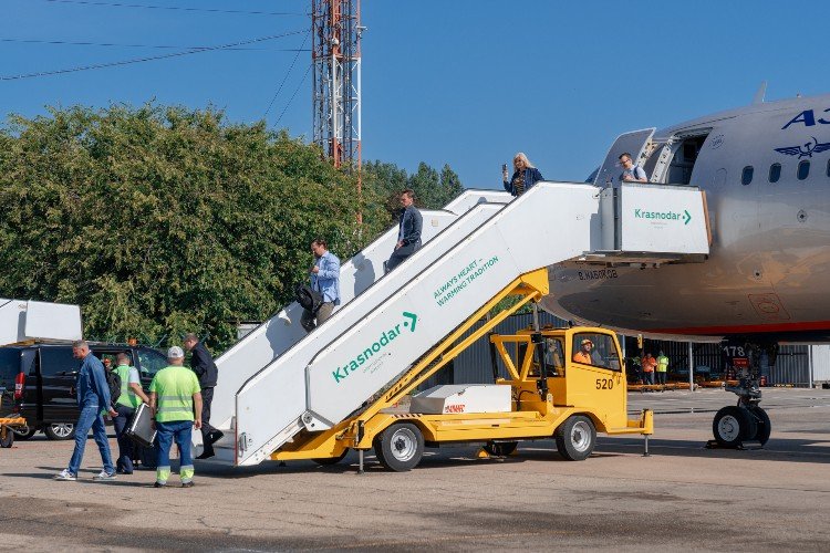 люди сходят с трапа самолета