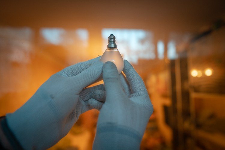 руки держат лампочку