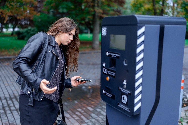 Девушка оплачивает парковку