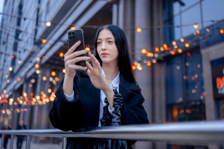 Девушка что-то набирает в телефоне