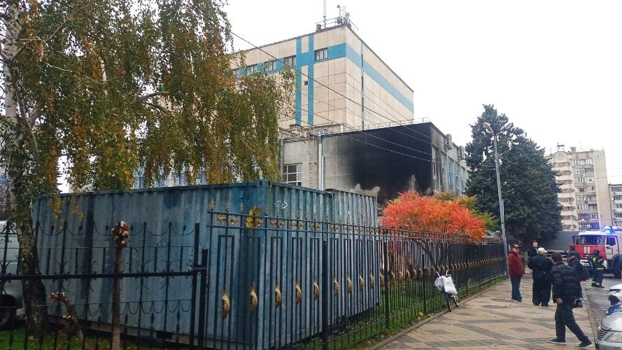 люди идут мимо театра