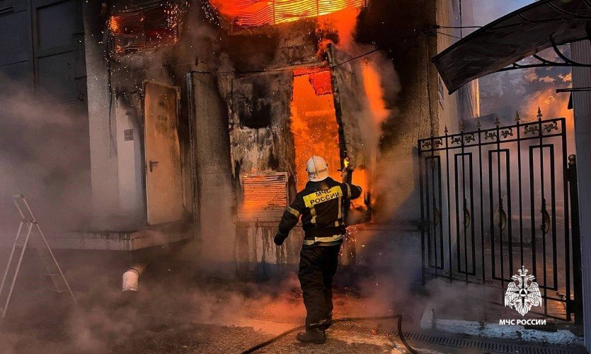 пожарный тушит огонь