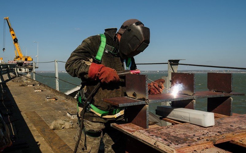 рабочий работает со сваркой