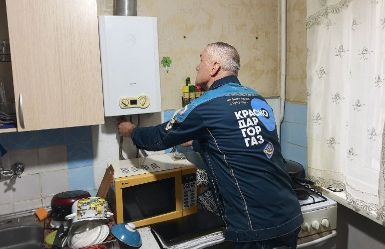 газовщик проверяет оборудование на кухне