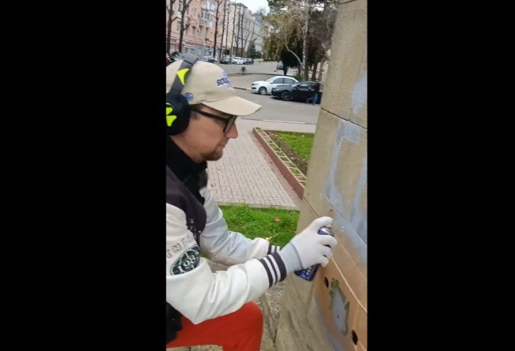 Мужчина расписывает памятник Ленину