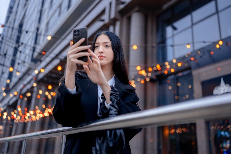 девушка стоит с телефоном