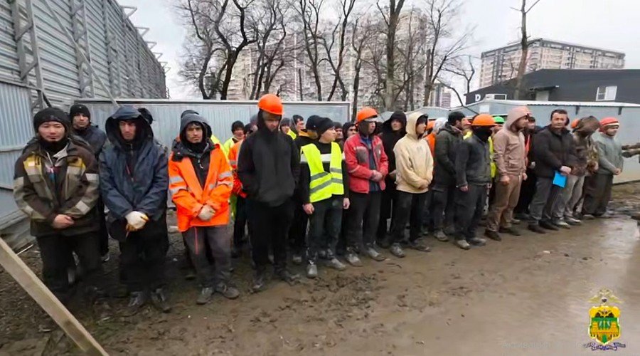 мигранты стоят на стройке
