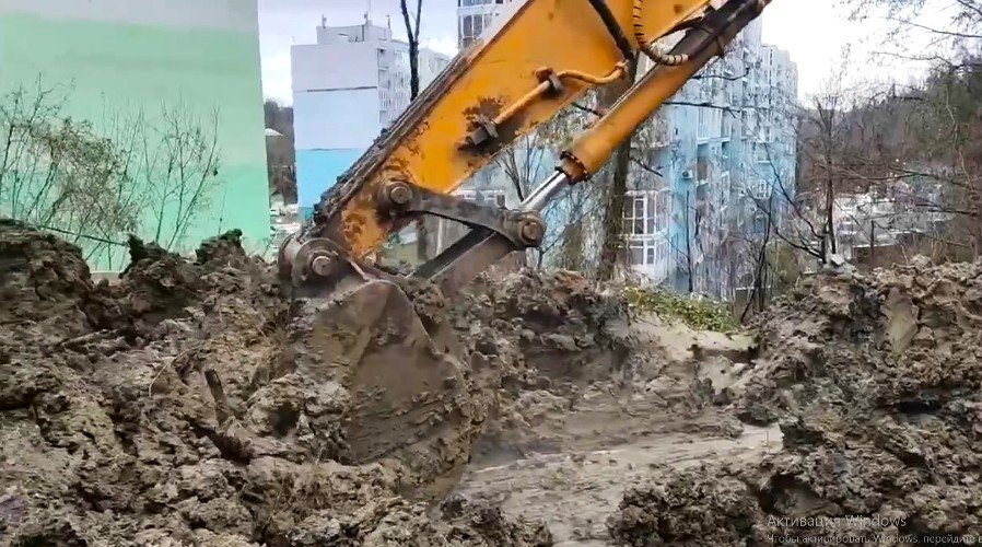 бульдозер убирает землю около МКД