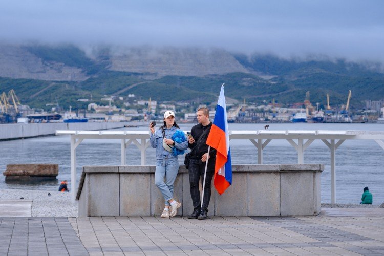 люди с флагами стоят у парапета