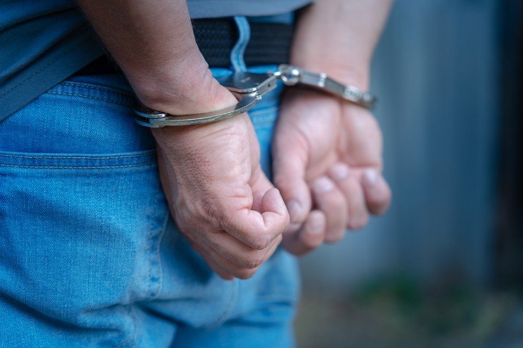 Руки в наручниках у мужчины