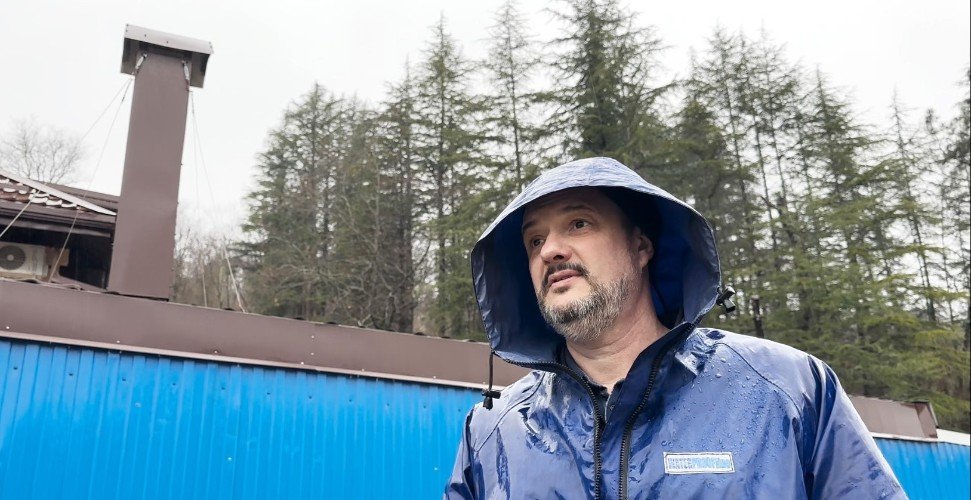 Мужчина стоит около дома