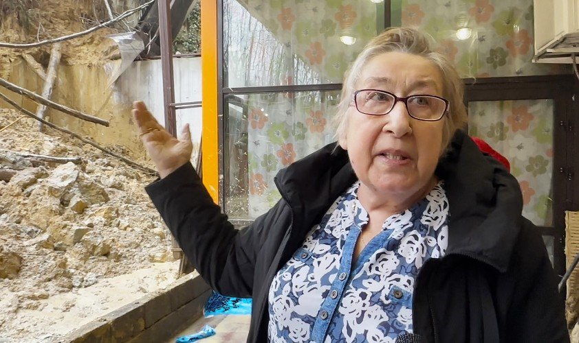 женщина показывает на оползень