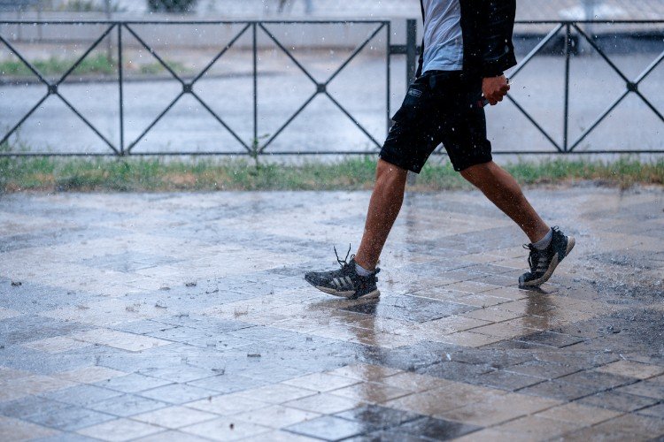 человек идет под дождем.