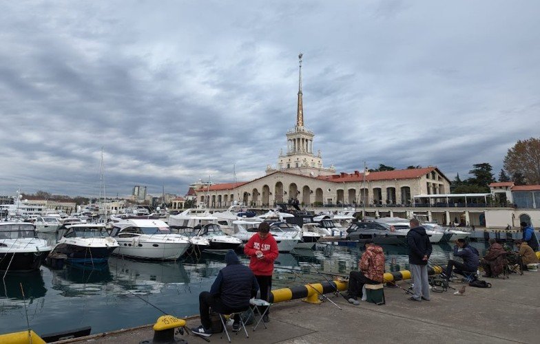 рыбаки сидят на пирсе морпорта