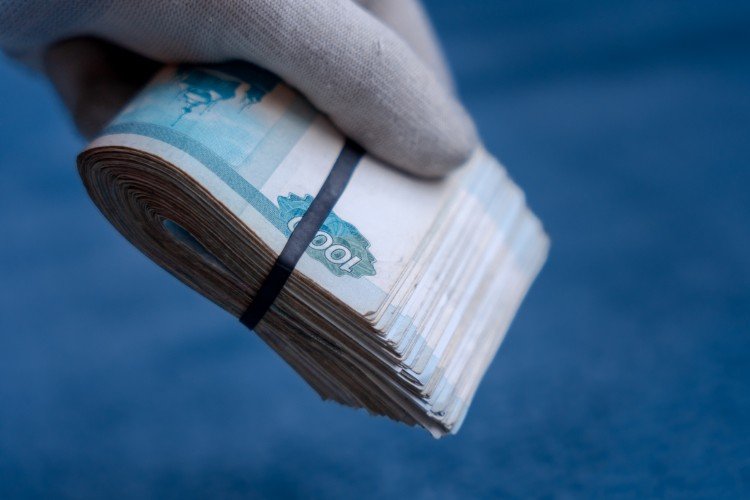 рука держит пачку денег