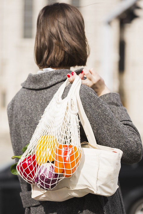 Девушка несет в руках авоську и шоппер