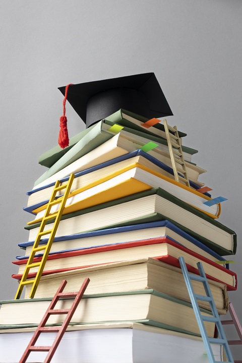 Стопка книг и лесенки, ведущие к шапочке выпускника университета