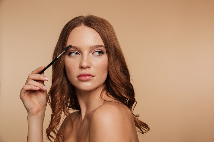 beauty-portrait-calm-ginger-woman-with-long-hair-looking-away-posing-sideways-while-combing-her-eyebrows-with-brush.jpg Портрет молодой девушки с щеточкой для бровей у лица