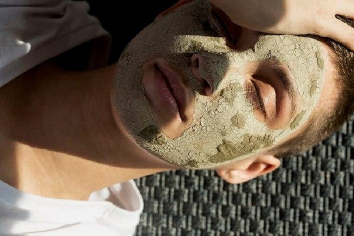 Девушка с грязевой маской лежит на солнце