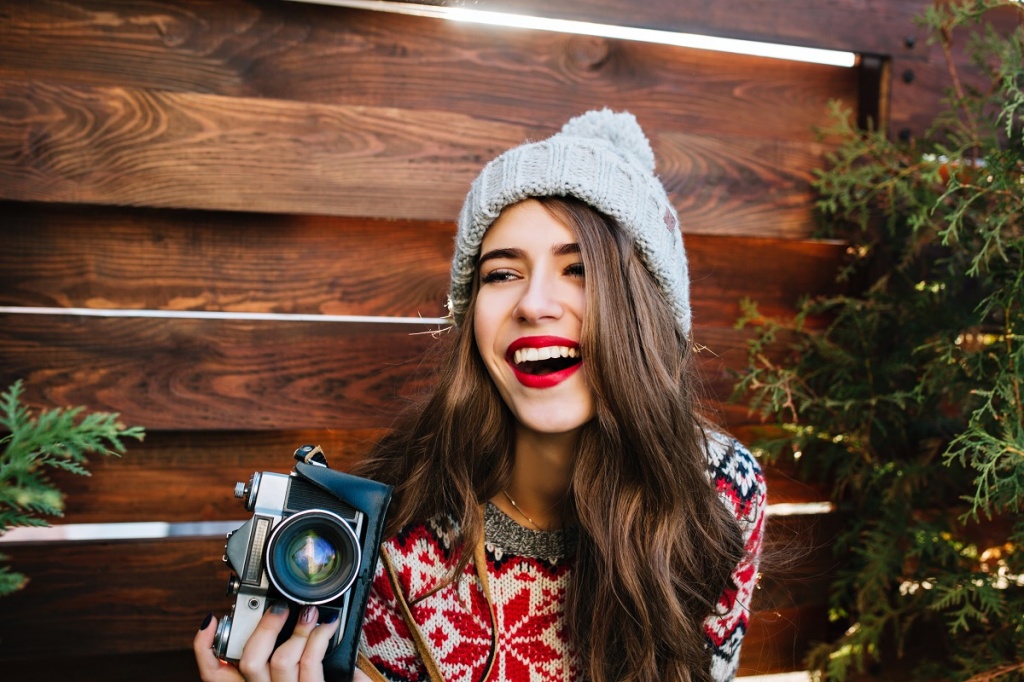 Портрет молодой девушки с фотоаппаратом на новогодней вечеринке