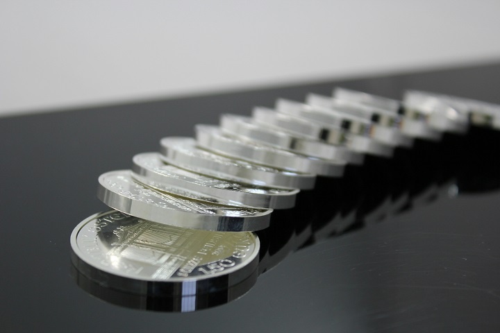 Серебряные монеты лежат в ряд на столе 