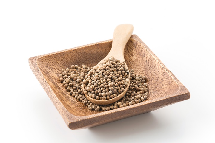 Семена кориандра в деревянной посуде 
