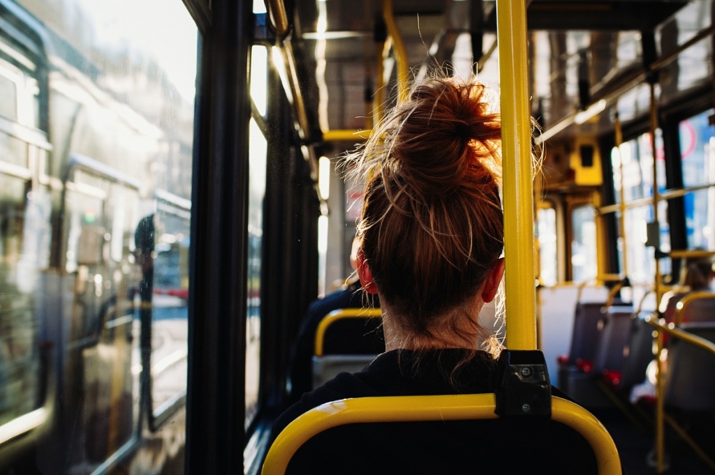 Молодая женщина сидит в автобусе