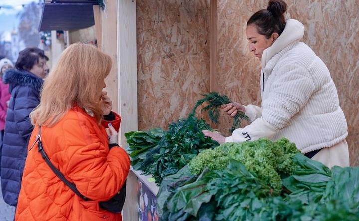 Женщина покупает свежую зелень