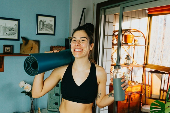 Счастливая молодая женщина готовится к фитнес-тренировке