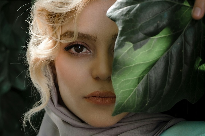 Красивая молодая женщина с зеленым листом 