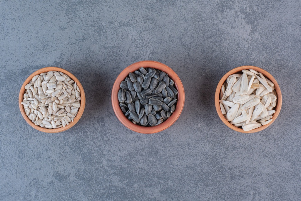 different-sunflower-seeds-bowls-blue-surface.jpg
