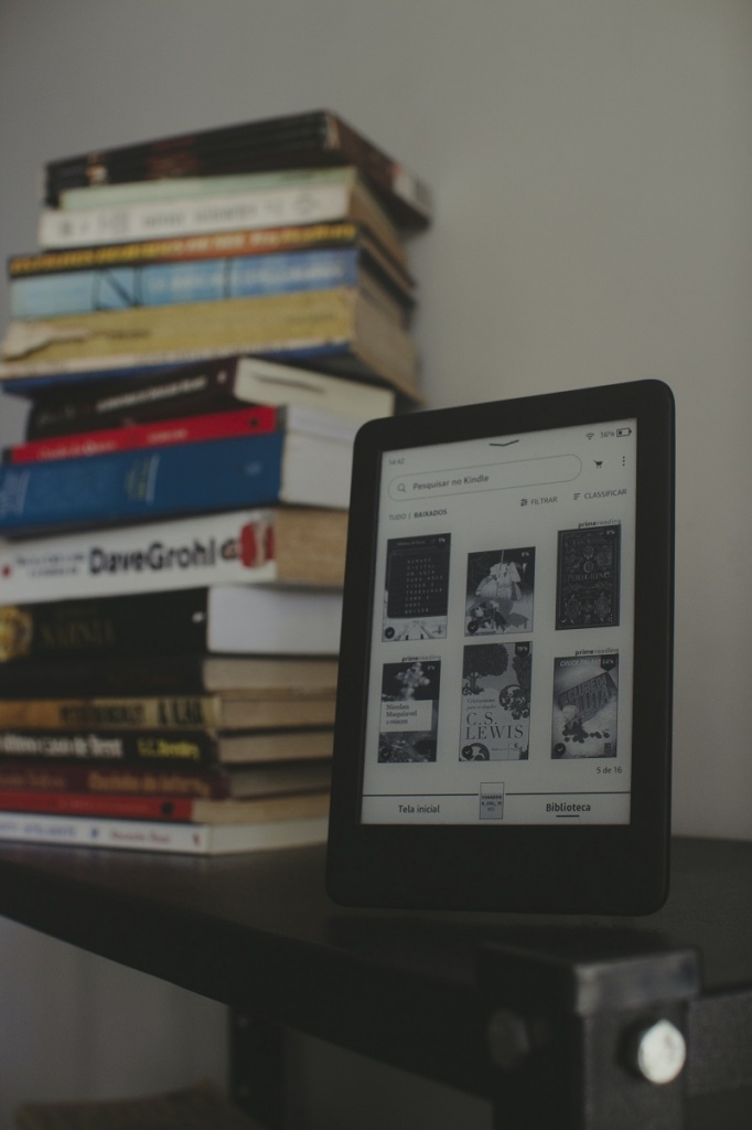 felipepelaquim-tIgkgognTwc-unsplash.jpg Стопка бумажных книг и электронная на столе