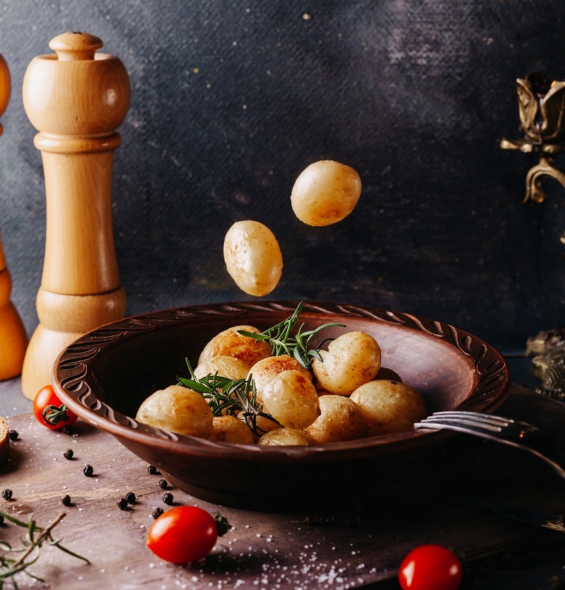 Печеный картофель в тарелке со свежими помидорами