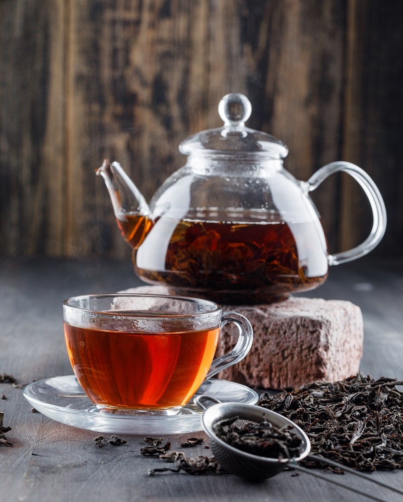 black-tea-teapot-cup-with-dry-tea-brick-side-view-wooden-surface.jpg Чашка чая с чайником стоят на столе