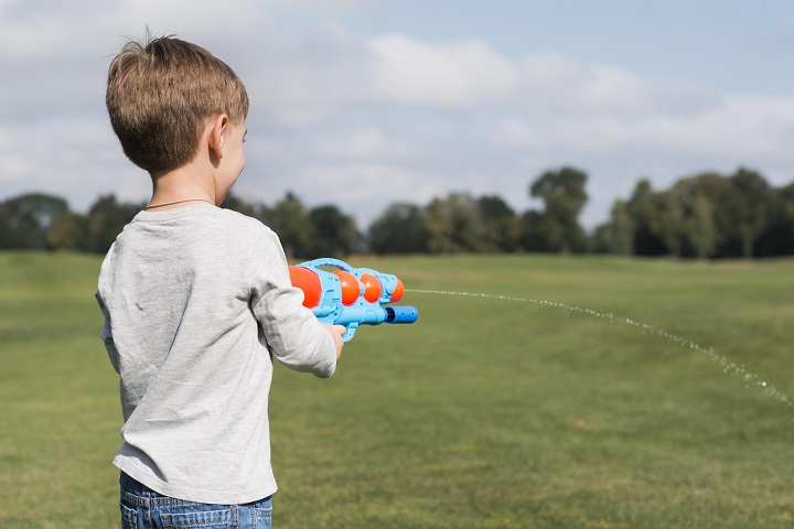 boy-playing-with-water-pistol-shoulder.jpg Мальчик играет с водным пистолетом