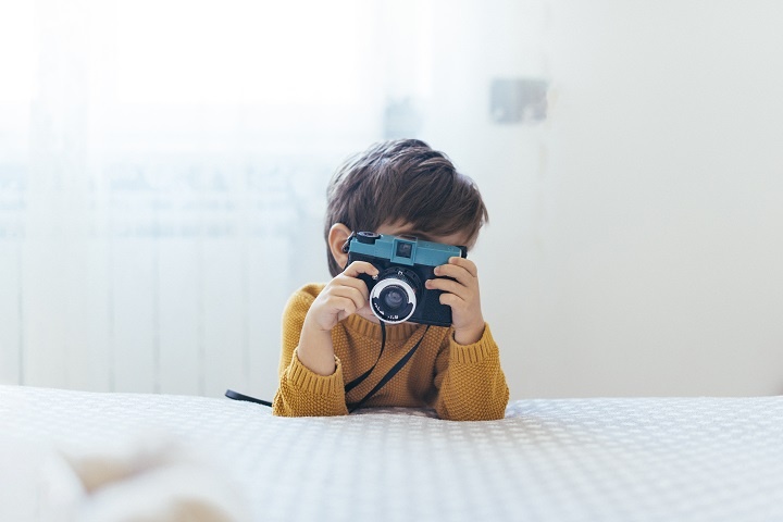 kid-taking-photo.jpg Мальчик держит в руках игрушечный фотоаппарат