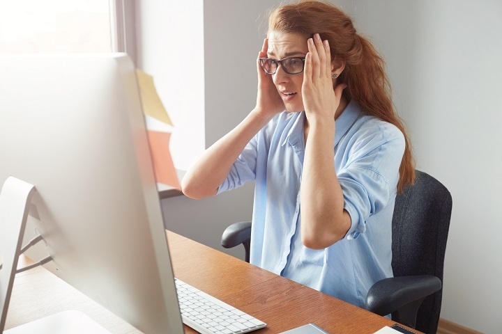portrait-depressed-female-entrepreneur-sitting-front-computer-while-working-office.jpg Молодая женщина сидит перед монитором компьютера и держится за виски