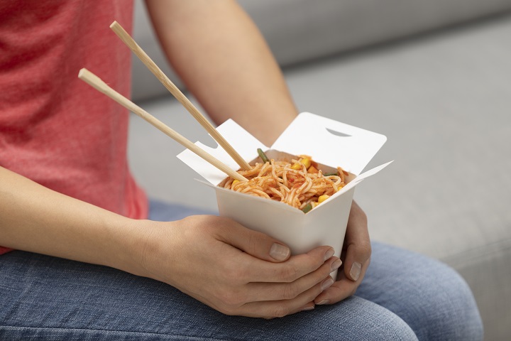close-up-hands-holding-noodle-box.jpg девушка держит на руках лапшу с овощами