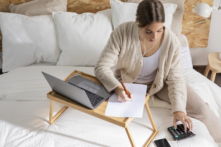 medium-shot-woman-working-bed.jpg Девушка работает с ноутбуком, сидя на диване