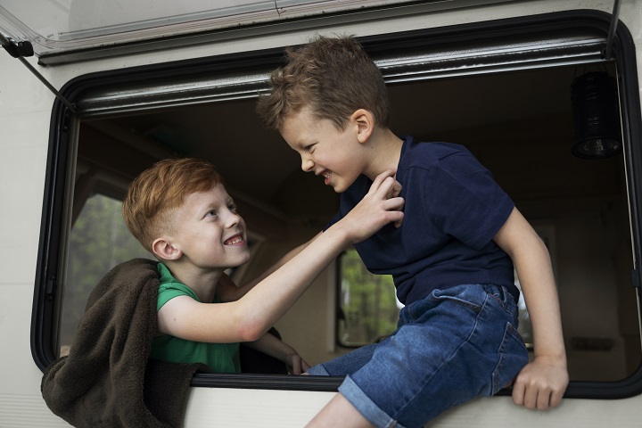 Дружеская потасовка между детьми в машине side-view-smiley-kids-camper-van.jpg