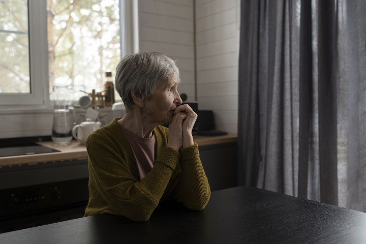 medium-shot-senior-woman-sitting-table.jpg Пожилая женщина сидит за столом и смотрит в окно